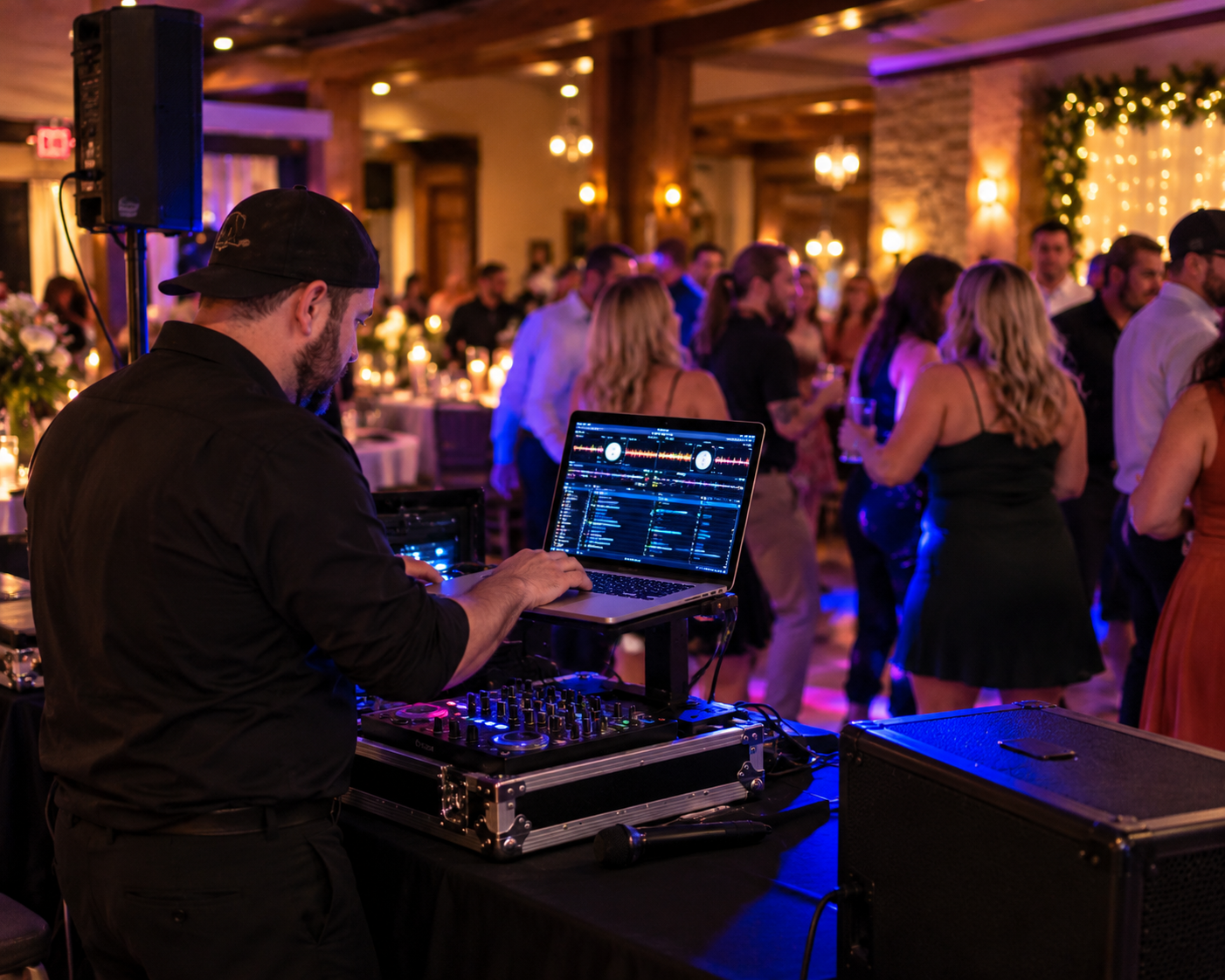 Mobile DJ operating a laptop and compact soundboard at an event in Central Alberta
