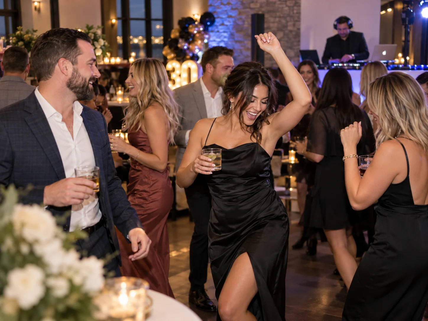 Guests dancing at a private party with a DJ performing in the background